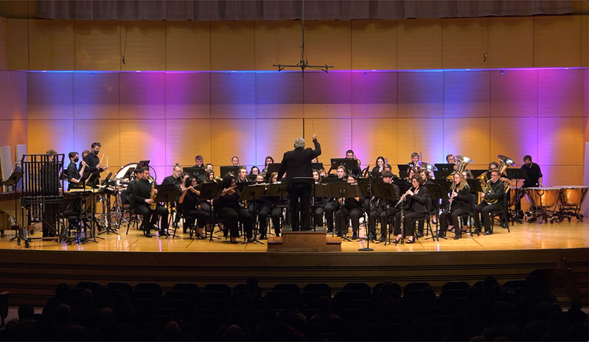 The CMU Wind Symphony performing on stage at Staples Family Concert Hall.